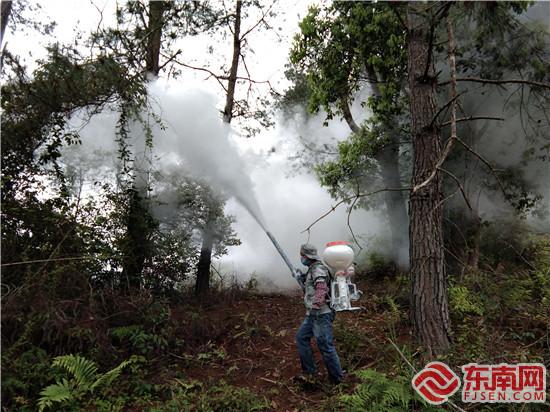 技术工人用喷药机往树上喷洒药粉（摄影：刘宝进）.jpg