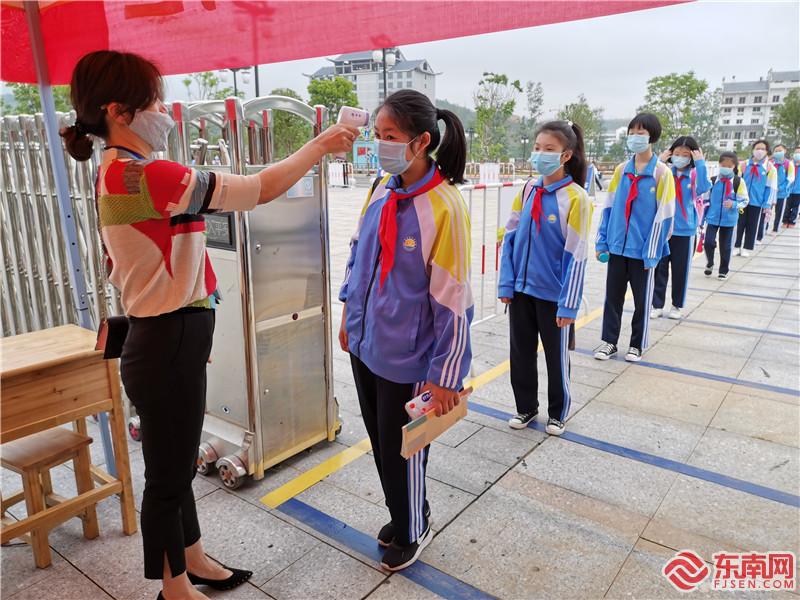 泰宁县文昌小学的学生进入学校前 正在排队进行测量体温 熊明欢 摄.jpg