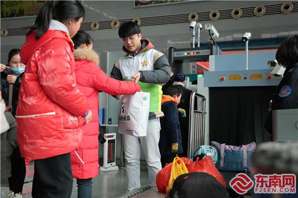 在建宁县北站，铁路青年志愿者正在帮助旅客提行李。 张海根 摄.jpg