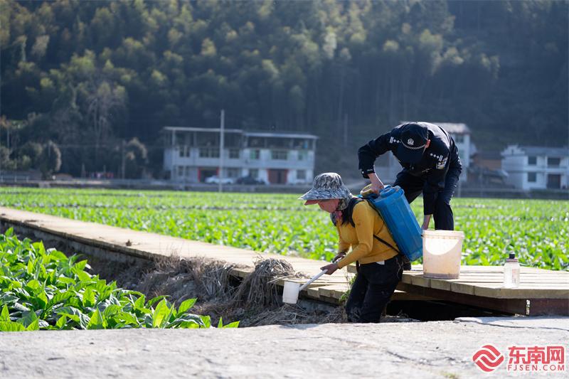 图为3月20日，民警协助烟农播洒化肥.jpg