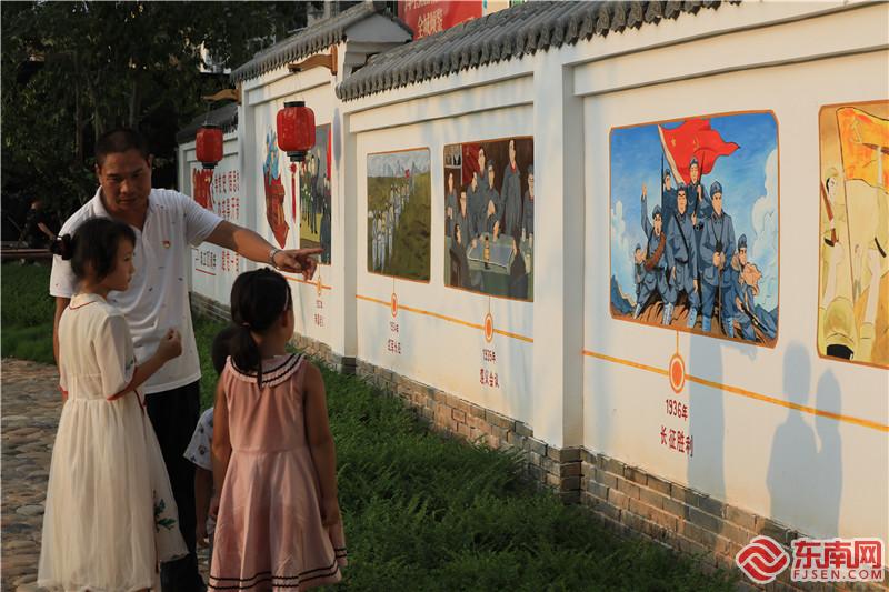 在党史教育文化墙，一位党员正在向小朋友讲述红色故事。董观生摄.jpg