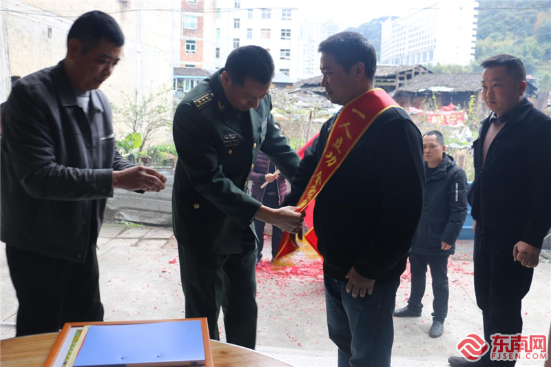人武部部长为李招军家属披戴绶带。拍摄：陈开奖.png