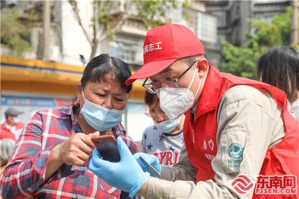 3月21日，国网三明供电公司电网志工在三明市东安小学核酸检测点协助群众进行扫码登记 唐伟 摄.jpg