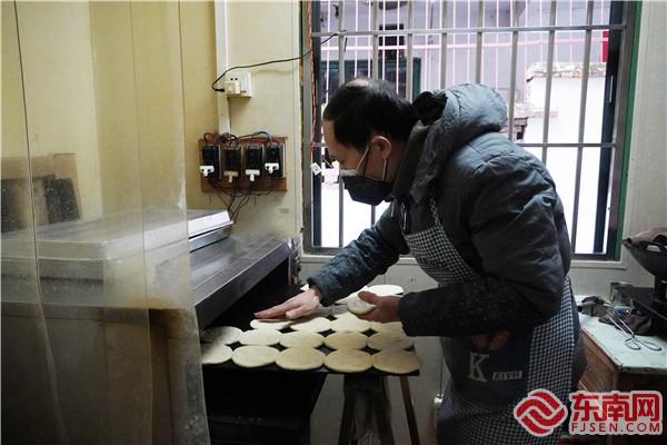 梅梁华从电烤箱中放入烧饼.jpg