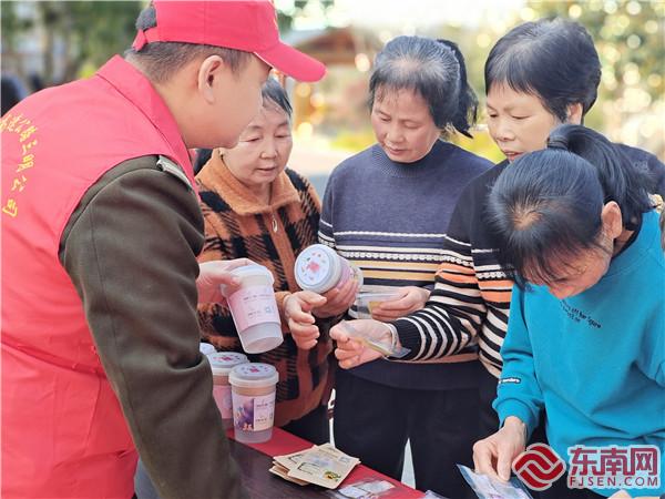 志愿者为旅客发种子  张秀华.jpg