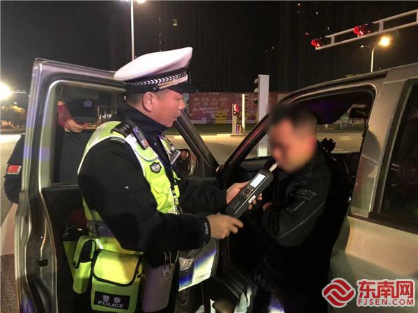 图为：民警在现场对男子进行呼气式酒精检验。沙县公安供图.jpg