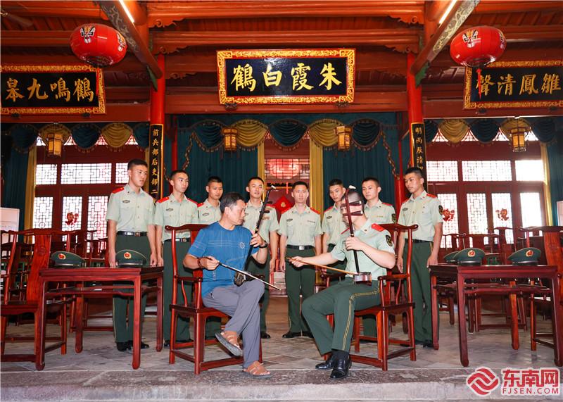 9、图为武警官兵与“梅林戏”二胡演奏老师切磋二胡技艺（摄影：钟炜俊）.jpg